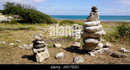 Stones pyramid on the seashore in summer day Stock Photo