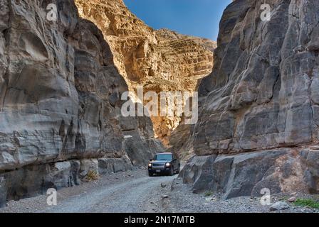 Car squeezing through the narrows of Titus Canyon in Grapevine Mountains, Death Valley National Park, California, USA Stock Photo