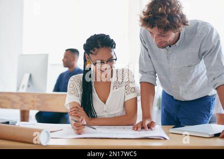 Working together for better results. two young designers working together in their office. Stock Photo