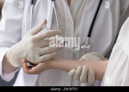 Pediatrician doctor giving shot to child against flu Stock Photo