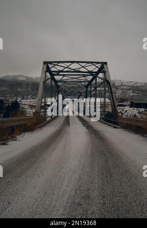 100 yr old steel and wood bridge on cloudy snow day Stock Photo