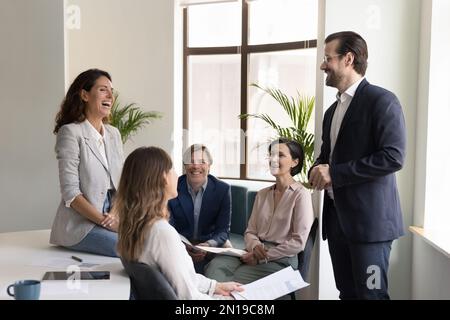 Happy confident business leader man speaking to team Stock Photo