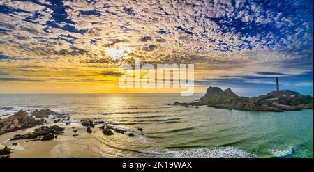 Landscape of small island with ancient lighthouse at sunrise sky is beautiful and peaceful. This is only ancient lighthouse is located on island Stock Photo