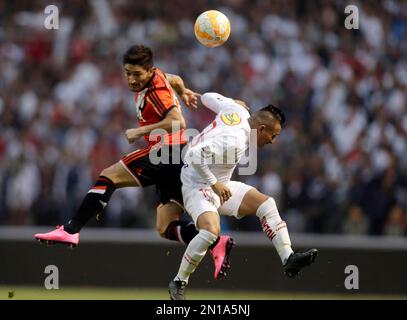 Rafinha of Brazil's Flamengo heads the ball challenged by Milton Casco of  Argentina's River Plate during the Copa Libertadores final soccer match at  the Monumental stadium in Lima, Peru, Saturday, Nov. 23