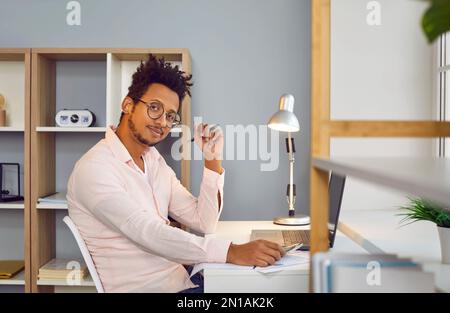 Portrait of an African American student or businessman sitting at his working desk at home Stock Photo