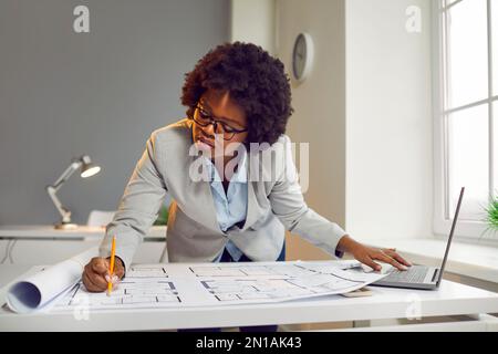 Beautiful young woman architect working on architectural project in office Stock Photo