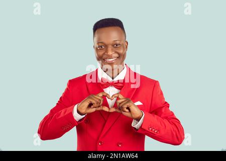 Happy African American charity person in red suit forming heart shape with his hands Stock Photo
