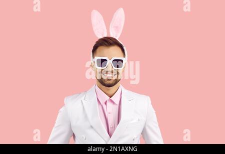 Studio portrait of happy smiling handsome young man in suit and easter bunny ears Stock Photo