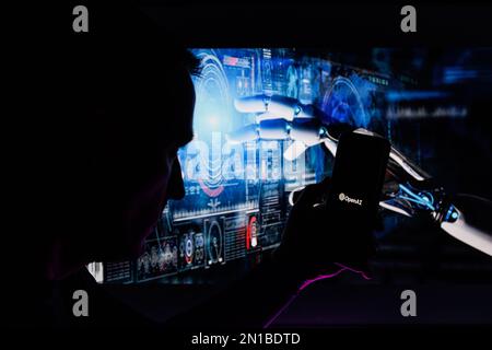 Man silhouette holding smartphone with ChatGPT logo in futuristic background. ChatGPT is AI chatbot which is made by OpenAI Stock Photo