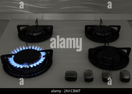 Modern gas cooktop with burning blue flames in kitchen Stock Photo