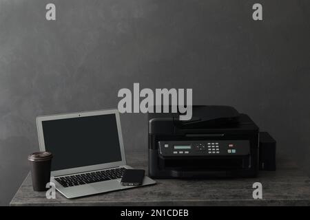 New modern printer, smartphone and laptop on grey table Stock Photo