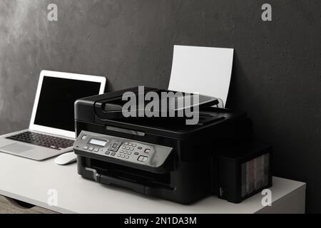 New modern printer and laptop on white table Stock Photo