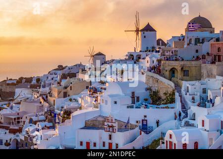 Sunset over windmills, Oia, on the clifftop overlooking the caldera, Santorini, The Cyclades, Aegean Sea, Greek Islands, Greece, Europe Stock Photo