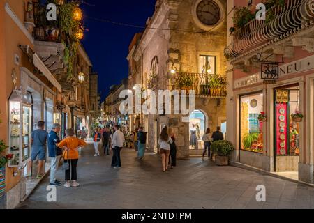 View of cafes and restaurants on busy street in Taormina at dusk, Taormina, Sicily, Italy, Mediterranean, Europe Stock Photo