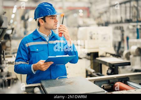 Professional Engineering of modern factory checking  to automatic machinery. Engineering with clipboard Programmable Logic Controller to manage large Stock Photo