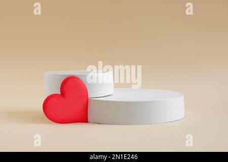 Podium for cosmetic presentation on beige neutral background. Abstract minimal geometrical form. Cylinder pedestal sphere, soft shadow. Two geometric Stock Photo