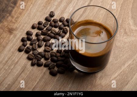 Roasted coffee beans with espresso in glass cup,top view Stock Photo