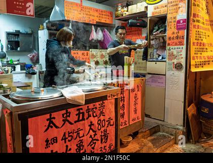 Hong Kong - Open air restaurant stall selling food in Yau Ma Tei - December 2022 Stock Photo
