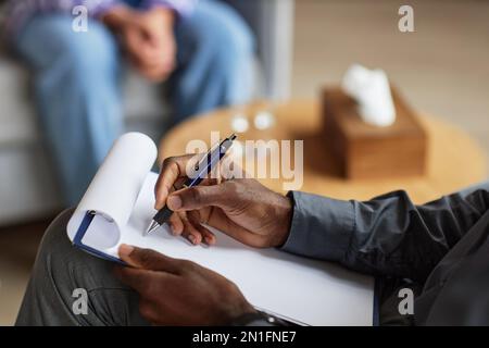 Hands of phsycologist talking to patient and taking notes in document Stock Photo