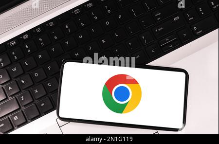 Google chrome inside mobile screen with laptop in the backdrop, famous browser editorial background Stock Photo