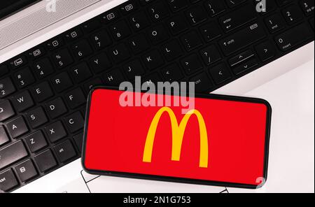 Modern Fast food Mcdonalds on mobile screen with laptop in the backdrop, food and drink editorial concept background Stock Photo