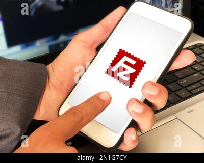 Modern file transfer protocol software filezilla on mobile screen with man touching, editorial background Stock Photo