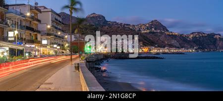 View of Taormina and Giardini Naxos promenade viewed from Giardini Naxos at dusk, Sicily, Mediterranean, Italy, Mediterranean, Europe Stock Photo