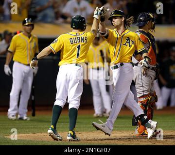 Oakland Athletics' Yoenis Cespedes, right, celebrates his solo home run  with teammate Josh Reddick (16) during the fourth inning of the second game  of a doubleheader baseball game against the Seattle Mariners