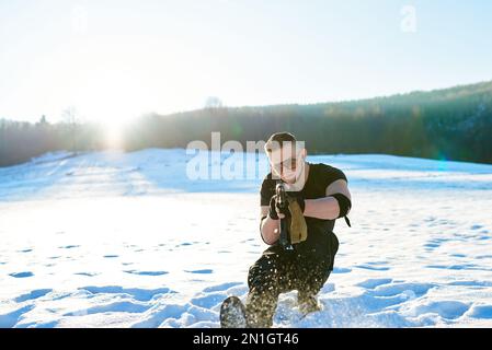 soldier with weapons in forest somewhere above the Arctic Circle Stock Photo