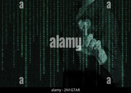 A hand pressing a virtual button with a matrix binary digital code, a hologram on a dark background. The concept of artificial intelligence. The start Stock Photo