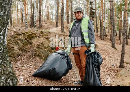 Big garbage bag in the woods. Picking up trash in the forest Stock Photo by  GalinkaZhi