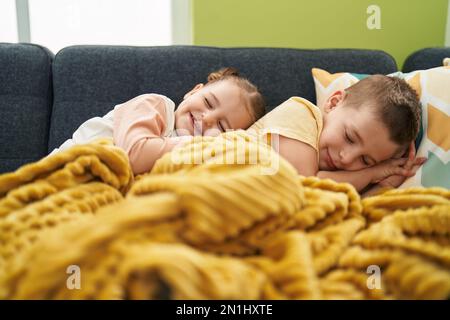 Two kids lying on sofa sleeping at home Stock Photo