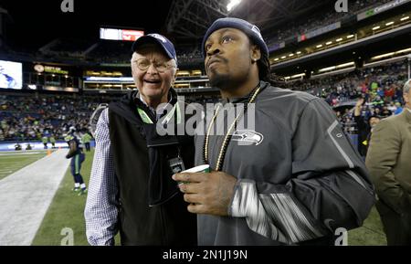 Seattle Seahawks owner Paul Allen, left, shakes hands with former Seahawks  tackle Walter Jones next to Jones' #71 jersey during a halftime ceremony to  induct Jones into the Seahawks Ring of Honor