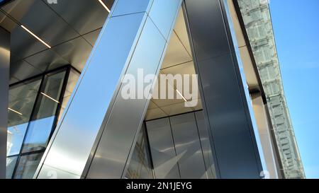 Combination of metal and glass wall material. Steel facade on columns. Abstract modern architecture. High-tech minimalist office building. Contemporar Stock Photo