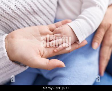 Mother and son lying on bed holding hand at home Stock Photo