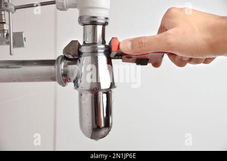 plumber fixing sink pipe with adjustable wrench Stock Photo