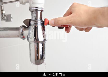 plumber fixing sink pipe with adjustable wrench Stock Photo