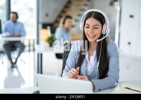 Call center worker communicating with client trying to sell company products during online meeting at office Stock Photo