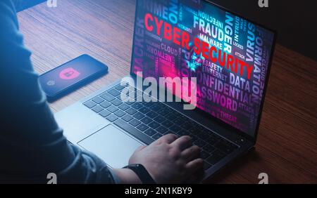 Woman using laptop with wall of words on screen about security technology. Cyber security concept. Future technology. Hacker detection. Stock Photo