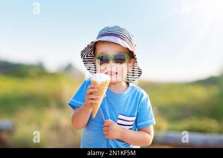 Unhappy boy tasted ice cream in a cone in nature Stock Photo