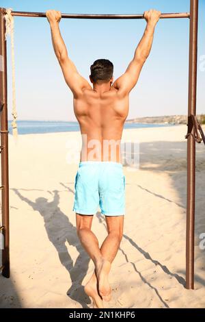 Man with slim body doing pull-ups Stock Photo