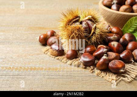 Fresh sweet edible chestnuts on wooden table Stock Photo