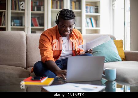Young african man working from home, using computer Stock Photo
