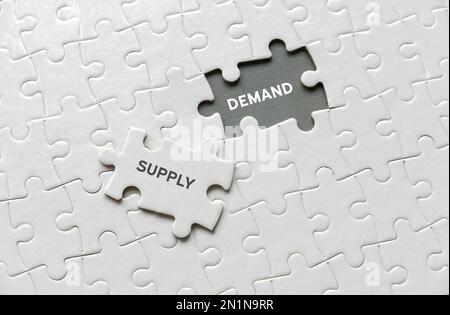 Selective focus of an empty space of jigsaw puzzle written with Demand and a piece of jigsaw puzzle written with Supply. Stock Photo