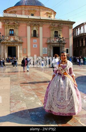 A girl in traditional costume in front of the Real Basílica de la Virgen de los Desamparados Plaza de la Virgen Valencia Spain Stock Photo