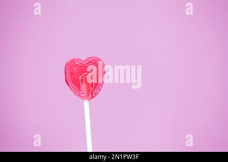 Heart Shaped Sugar Lollipop on pink background Stock Photo