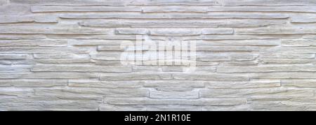 Bright wall cladding made of long, coarse facing stones with large joints Stock Photo