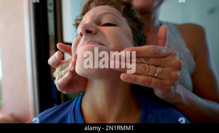 Closeup parent hands applying sunscreen lotion to child face closeup. Mother applies sun cream. Person putting sunblocker prevention Stock Photo