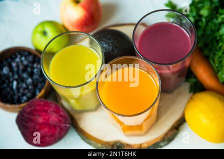Fresh organic juices, healthy eating, drinks, diet and detox concept , close up of glasses with different fruit or vegetable juices and food on table Stock Photo