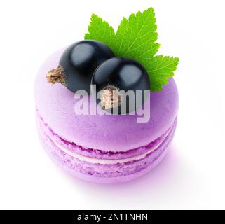 Close-up of two black currant berries on top of pink macaroon, isolated on white background Stock Photo